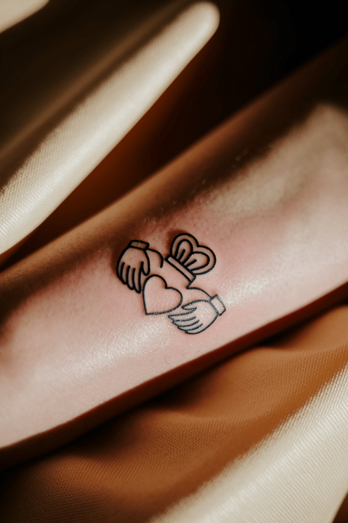 Claddagh tattoo on skin, symbolizing love, loyalty, and friendship with heart, hands, and crown.